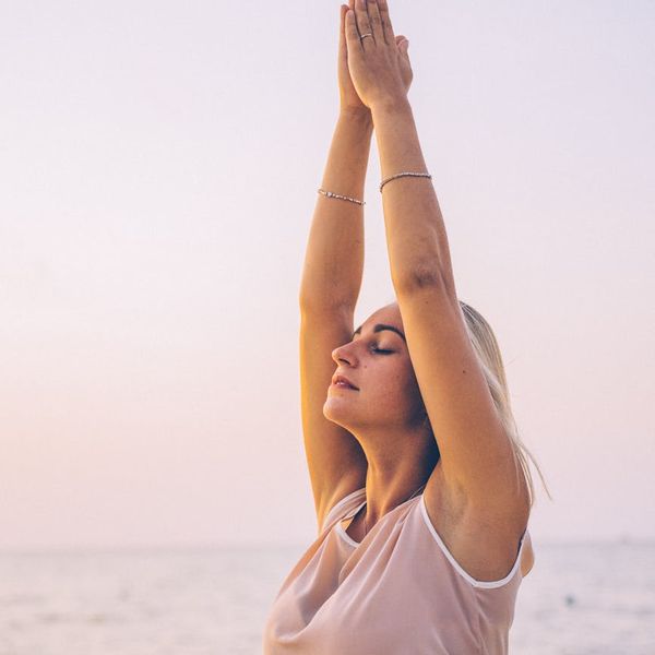 Person stretching outdoors during sunrise, feeling energized.